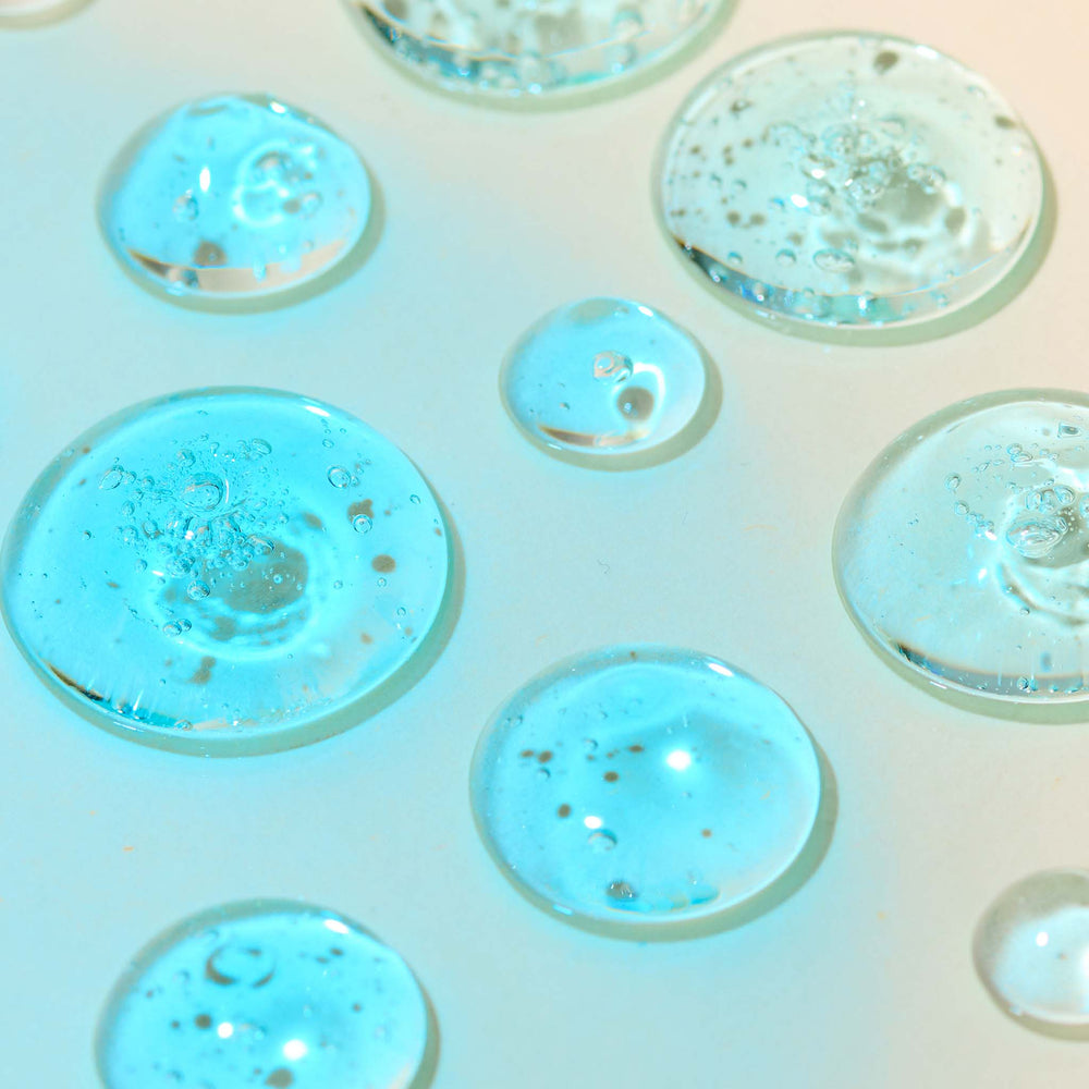 Close-up of aqua jelly bubbles on a light pink background