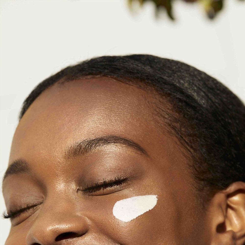 Close-up of a person with dermalogica porescreen on their cheek against a neutral background