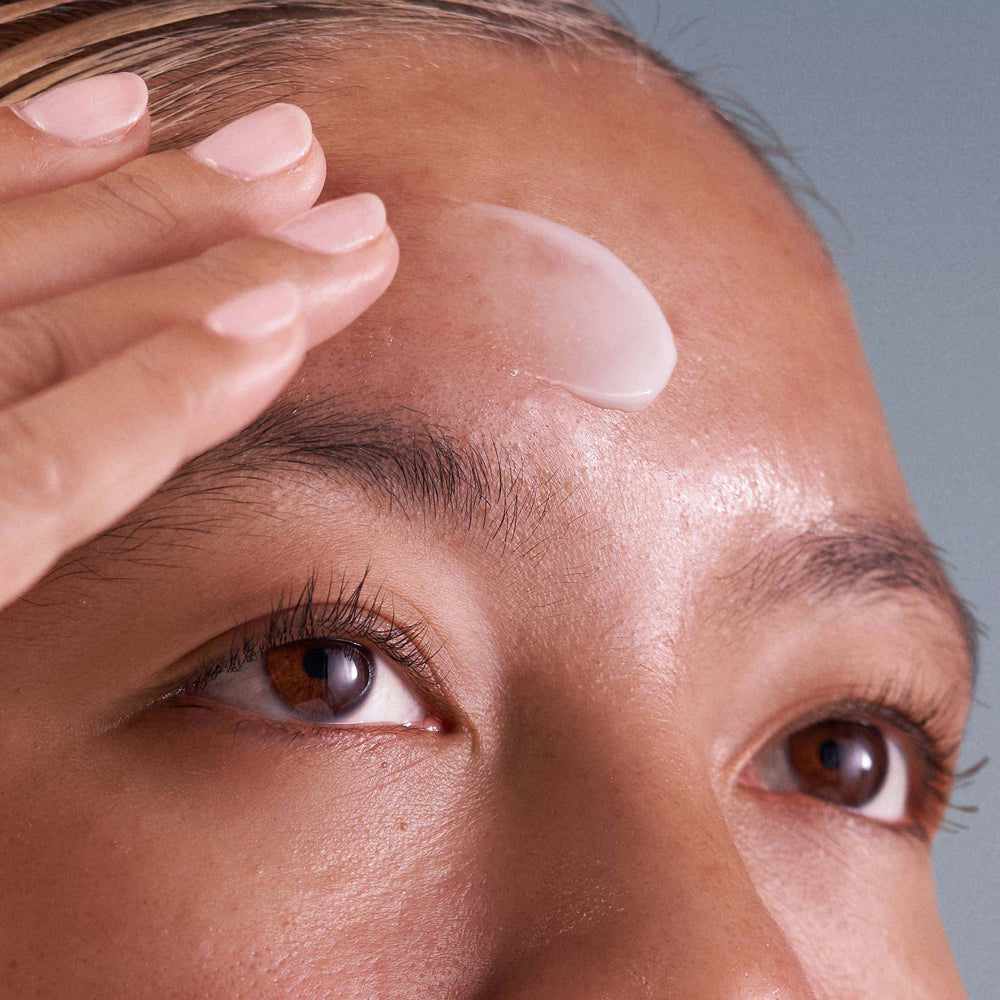 Person applying dermalogica pro-collagen banking serum to their face with a neutral background
